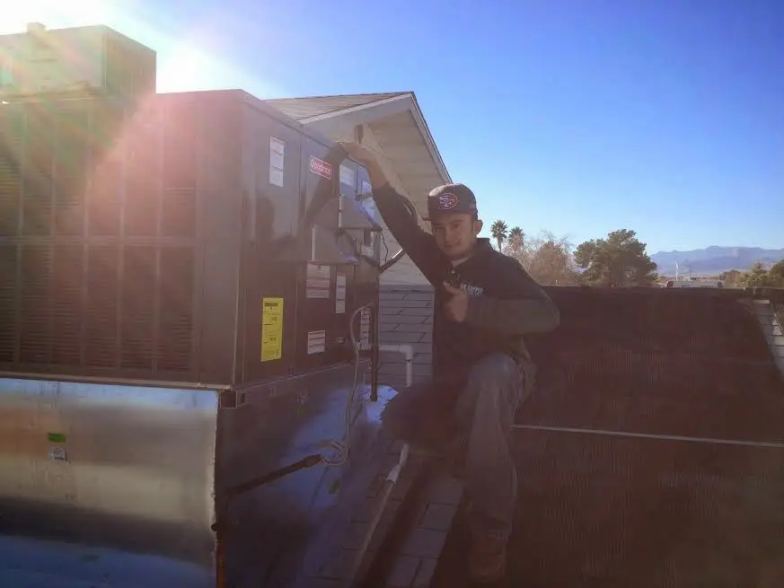 HVAC technician performing HVAC Inspection on a rooftop unit in Grand Ledge
